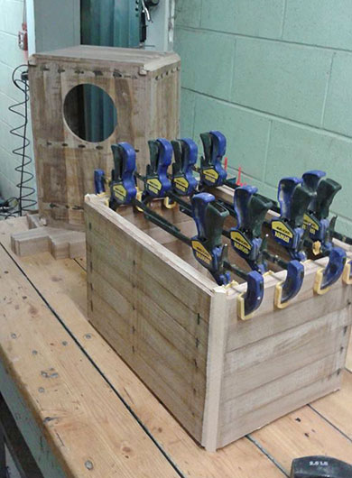 Eight clamps secure braces during construction of an Anointed Peruvian cajon in Illinois, USA